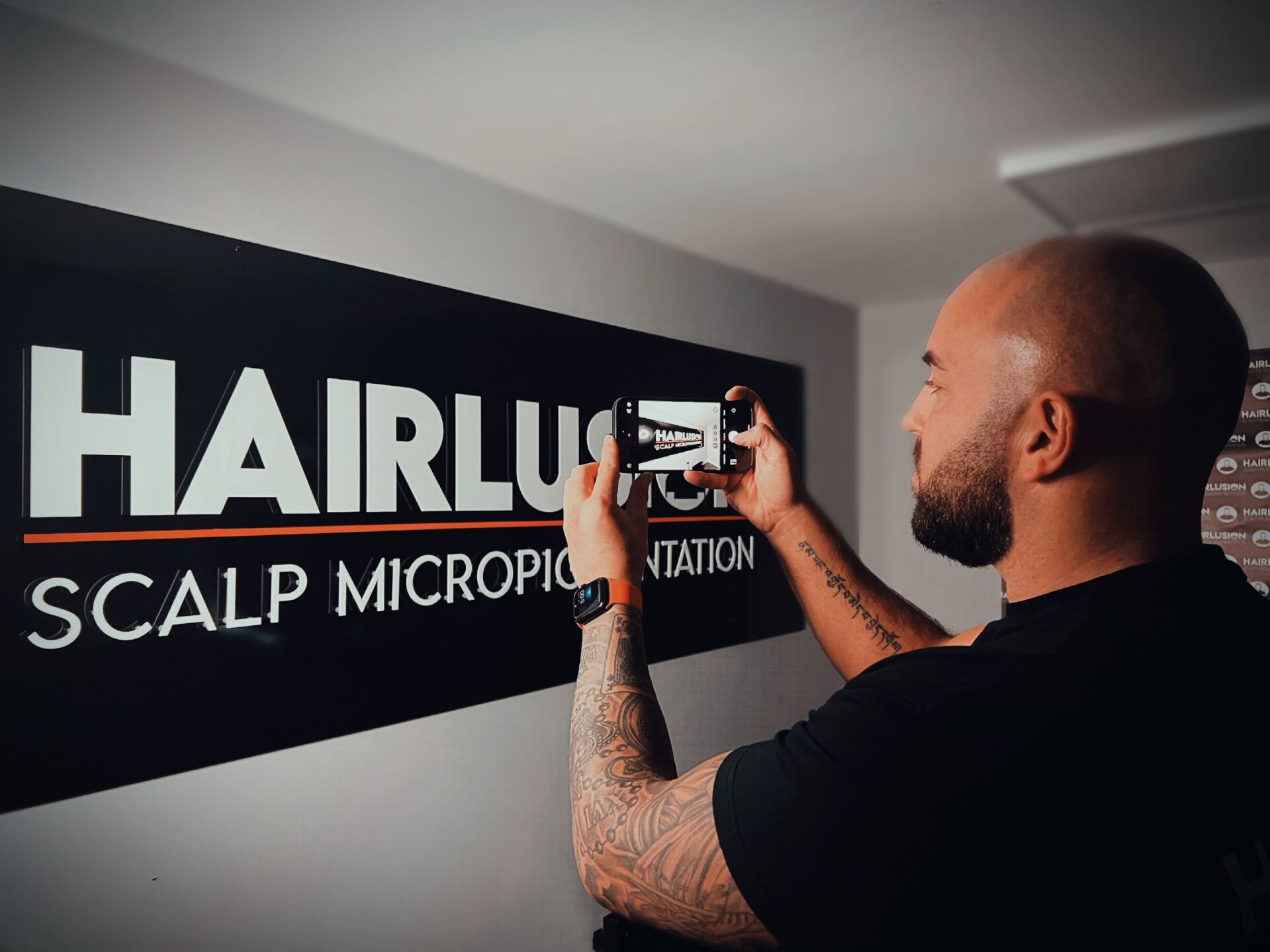 Joe taking a photo of the Hairlusion sign